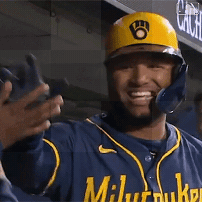 Baseball Player in Yellow Helmet and Blue Jersey Smiling and Waving