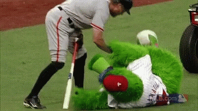 Baseball Player Standing Next To Green Mascot With Letter P GIF