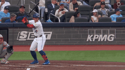 Jugador de béisbol balanceándose en lanzamiento frente a pancarta de KPMG GIF