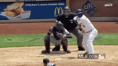 Baseball Player Swinging Bat At Ball In Front Of Crowd GIF