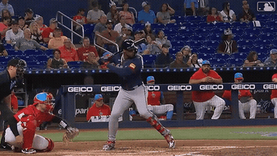 Baseball Player Swinging Bat In Front Of Geico Banner GIF