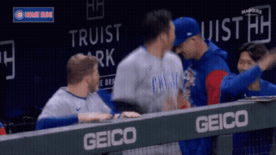 Baseball Players Hugging Behind Fence GIF