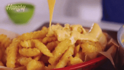 Basket Of French Fries With Cheese Being Poured GIF