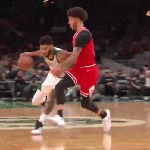 Basketball Player In Green Jersey Dribbling Past Red Jersey Defender GIF