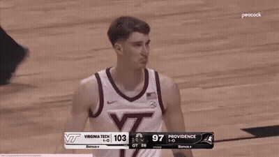 Basketball Player Standing On Court In Front Of Scoreboard GIF