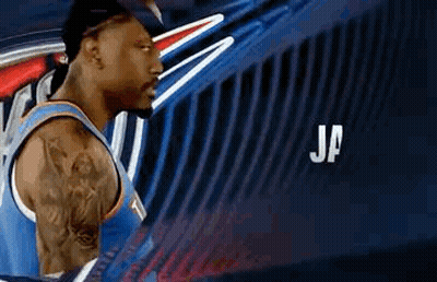 Basketball Player With Tattoo In Front Of Blue Wall GIF