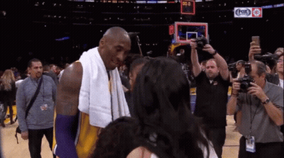 Basketball Player With Towel Talks To Woman At Fox Sports Scoreboard GIF