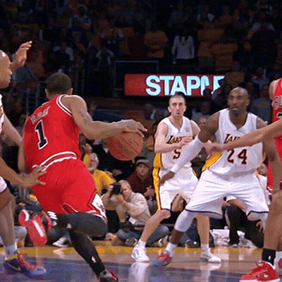 Basketball Players On A Court With A Staples Sign Behind Them GIF
