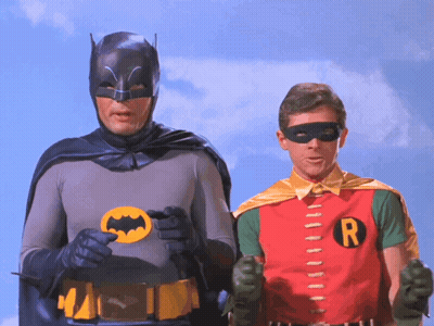 Batman And Robin Standing Together With R Shirt GIF