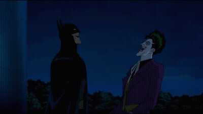 batman and the joker standing next to each other at night