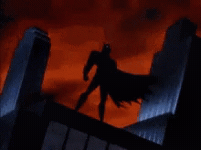 Batman Is Standing On The Roof Of A Building In A Storm . GIF