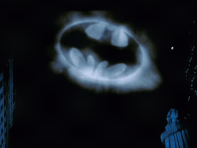 Batman Logo Projected On Dark Background GIF