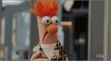 Beaker From The Muppets Is Holding A Cup Of Coffee In His Hand . GIF