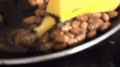 Beans Cooking In Pot With Yellow Spatula GIF