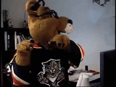 Bear Mascot Laying In Snow Feet Up GIF
