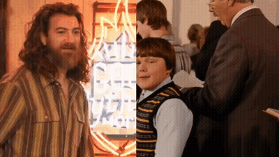 Bearded Man And Boy In Front Of Neon Rock Sign GIF