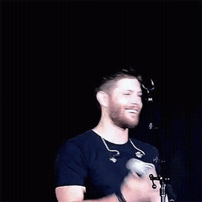 Bearded Man Applauding at Microphone