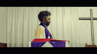 Bearded Man Before White Curtain And Cross GIF
