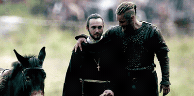 Bearded Man Beside Man With Cross Necklace GIF