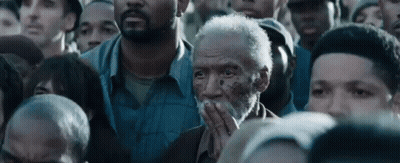 Bearded Man Covering Mouth In Crowd GIF