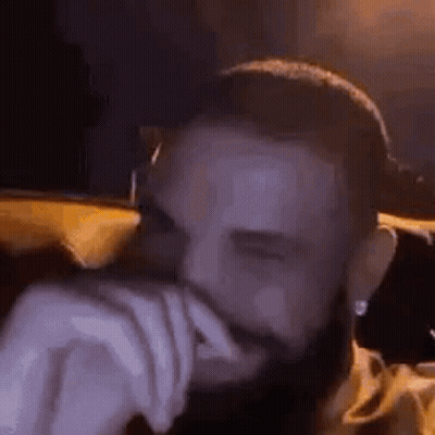 Bearded Man Covering Mouth On Couch GIF