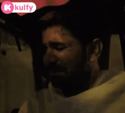 Bearded Man Crying In Dark Room With Kulfy Logo GIF