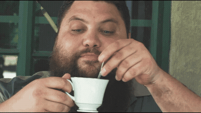 Bearded Man Drinking From White Cup With Spoon GIF