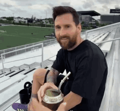 Bearded Man Drinking With Straw On Bleacher GIF