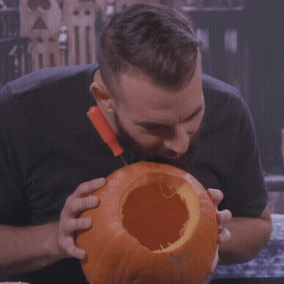 Bearded Man Eating Pumpkin With Knife GIF