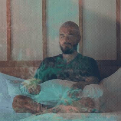 Bearded Man Eyes Closed Smoking On Bed GIF