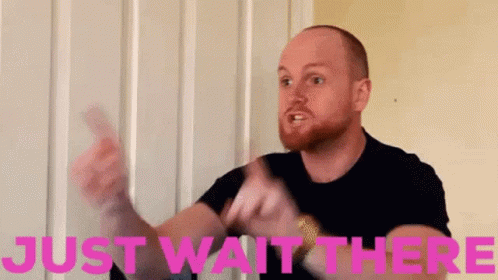 Bearded Man Holding Card Saying Just Wait There In Pink GIF