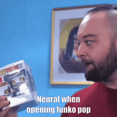 Bearded Man Holding Funko Pop In Front Of Blue Wall GIF