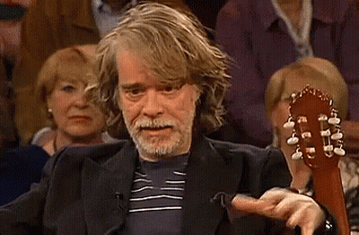 Bearded Man Holding Guitar In Front Of Crowd GIF