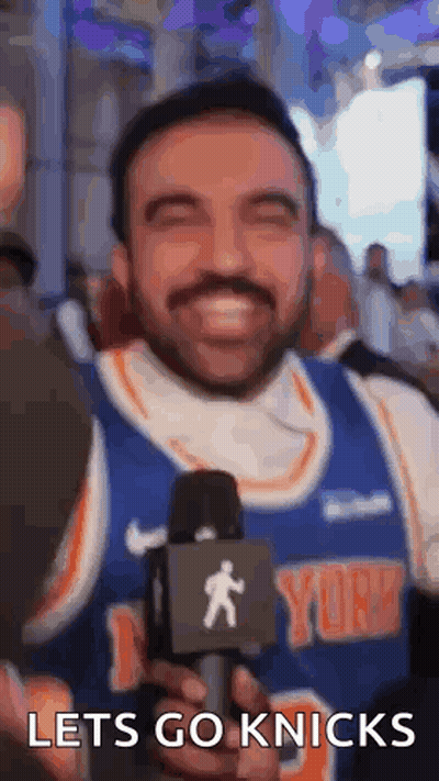 Bearded Man Holding Microphone Smiling In Knicks Jersey GIF