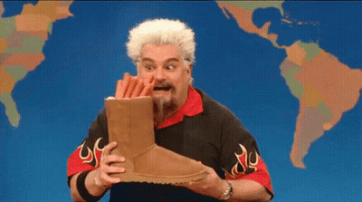 Bearded Man Holding Ugg Boots In Front Of World Map GIF