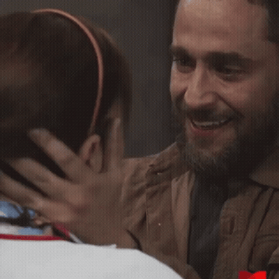 Bearded Man Hugging Another In Dark Room GIF