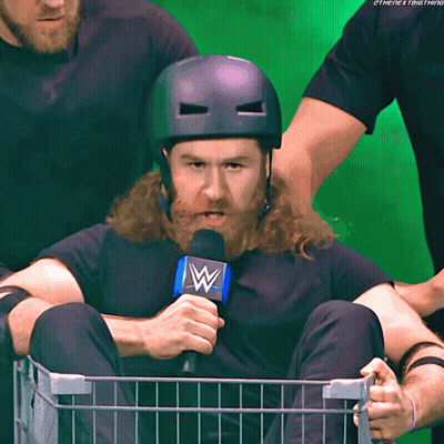 Bearded Man In Basket Holding Microphone With Letter W GIF