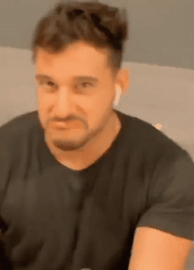 Bearded Man In Black Shirt And Ear Buds GIF