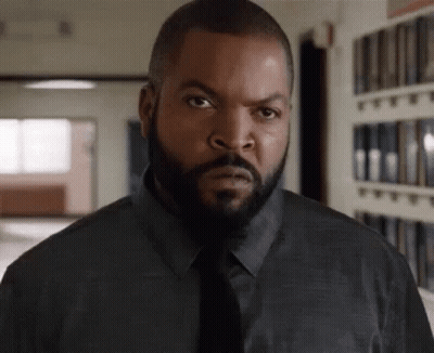 Bearded Man In Black Shirt And Tie Looking At Camera GIF