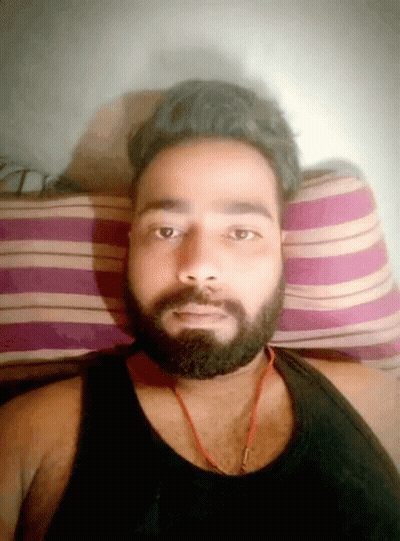 Bearded Man In Black Tank Top Laying On Striped Pillow GIF