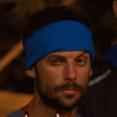 Bearded Man In Blue Headband Looks At Camera GIF