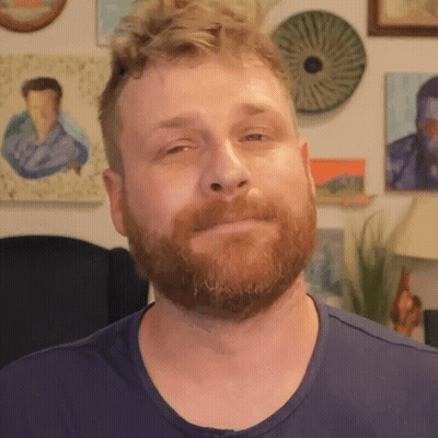 Bearded Man In Blue Shirt Looking At Camera GIF
