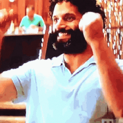 Bearded Man In Blue Shirt Talking On Cell Phone GIF