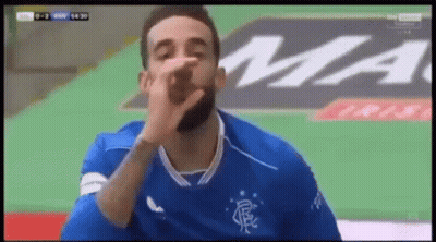 Bearded Man In Blue Soccer Jersey Blowing Kiss GIF