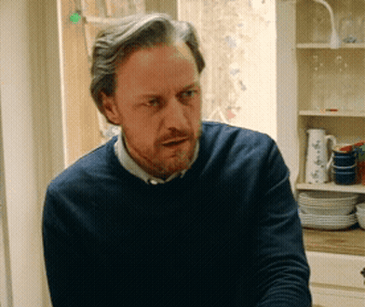 Bearded Man In Blue Sweater At Window GIF