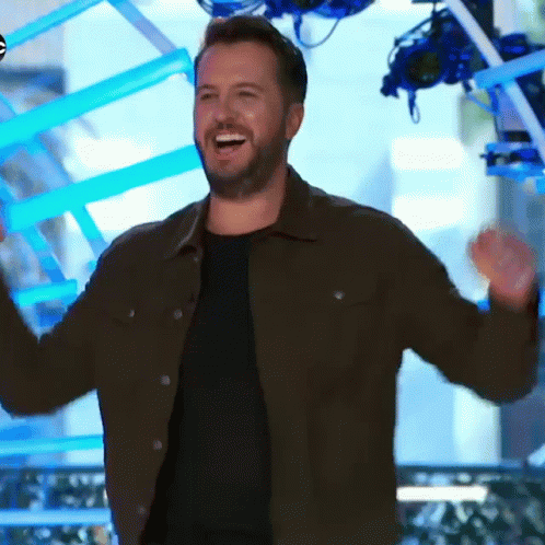 Bearded Man In Brown Jacket Smiling And Raising Arms GIF