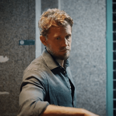 Bearded Man In Front Of Green Exit Sign GIF