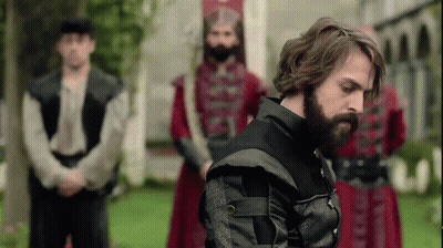 Bearded Man In Front Of Uniformed Men GIF