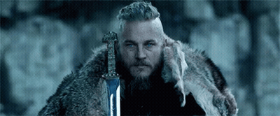 Bearded Man In Fur Coat Holding Sword GIF