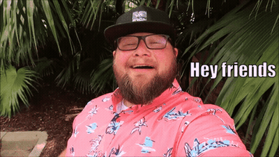 Bearded Man In Glasses And Pink Shirt Says Hey Friends GIF